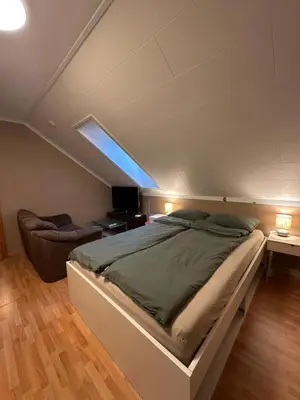 a bedroom with a large bed and a couch at Comfortable room - Double bed - Private bathroom - Free parking - Shared kitchen - Bus stop and store 2 min walk in Lunden