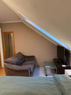 a living room with a couch and a tv at Comfortable room - Double bed - Private bathroom - Free parking - Shared kitchen - Bus stop and store 2 min walk in Lunden