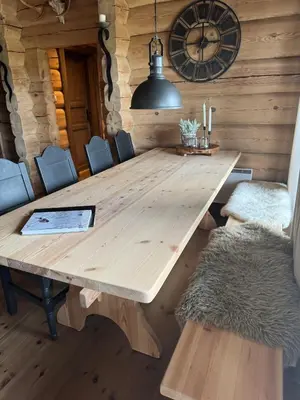 a wooden table in a room with chairs and a clock at Large and cozy family cabin with sauna in Trysil