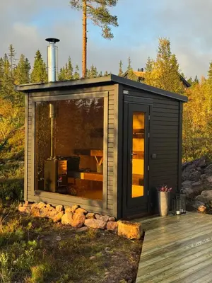 a cabin with a large window on a deck at Large and cozy family cabin with sauna in Trysil