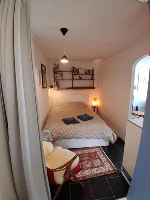 a small bedroom with a bed and a mirror at Appartement calme et central sur Bergen in Bergen