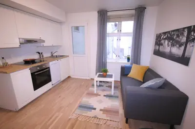 a living room with a couch and a kitchen at Super cozy 3-bedroom in picturesque neigborhood in Bergen