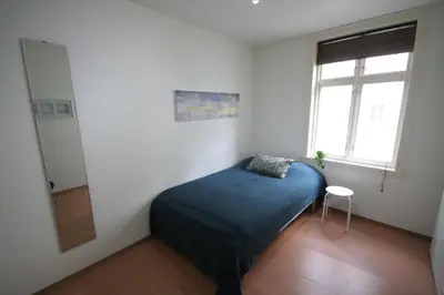 a bedroom with a blue bed and a window at Super cozy 3-bedroom in picturesque neigborhood in Bergen
