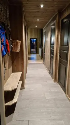 a hallway with wooden walls and a tile floor and a hallway with doors at Cabin Lillehammer, Nordseter, Sjusjøen in Lillehammer