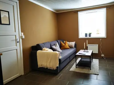 a living room with a blue couch and a window at Cozy apartment close to many experiences in Segalstad
