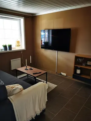 a living room with a flat screen tv on the wall at Cozy apartment close to many experiences in Segalstad