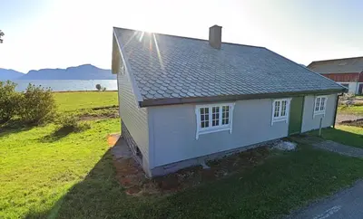 a small house on the side of a field at Gamlemgarden by Norgesbooking - house by the sea in Longva