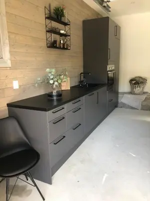 a kitchen with a counter with a sink and a chair at Large villa with boathouse in Lunde