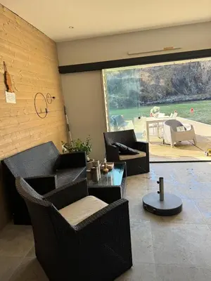 a living room with chairs and a table and a large window at Large villa with boathouse in Lunde