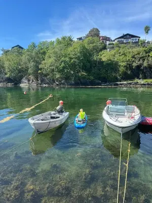 two people are in boats in the water at Large villa with boathouse in Lunde
