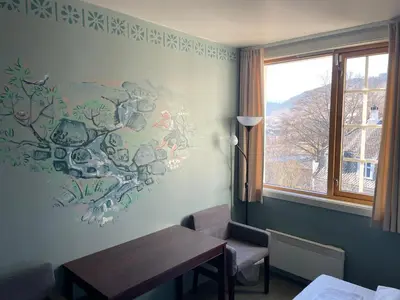 a dining room with a table and a painting on the wall at Ole Bull Akademiet in Vossevangen