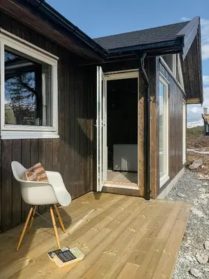 a white chair sitting on a wooden deck at Modern Cabin With Breathtaking View At Norefjell in Eggedal