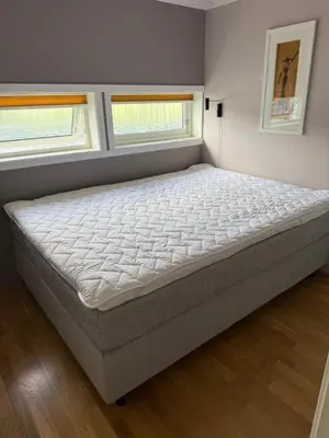 a large bed in a room with two windows at Seaside Cabin With Private Pier In Eidsvåg in Eidsvåg