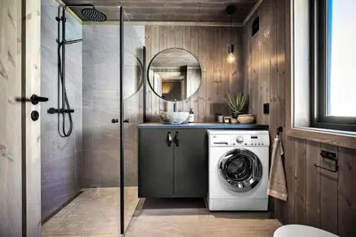 a washing machine in a bathroom with a mirror at New, cozy cottage on Norefjell with stunning views in Noresund