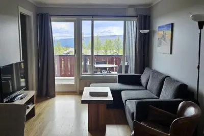 a living room with a couch and a large window at Appartment at Stølstunet in Beitostølen in Beitostøl