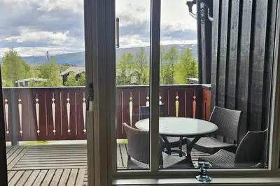 a patio with a table and chairs on a deck at Appartment at Stølstunet in Beitostølen in Beitostøl