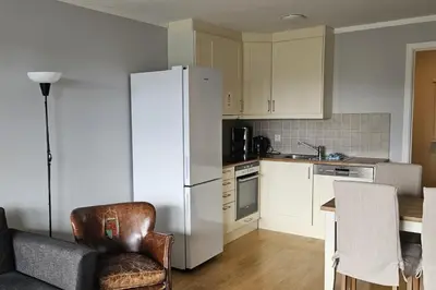 a kitchen with a refrigerator and a chair and a table at Appartment at Stølstunet in Beitostølen in Beitostøl