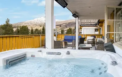 a jacuzzi tub on the patio of a house at Gorgeous Home In Bjorli With Wifi in Bjorli
