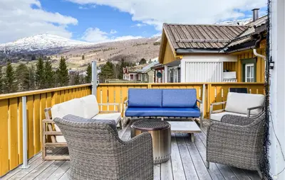 a deck with chairs and a table and a blue couch at Gorgeous Home In Bjorli With Wifi in Bjorli