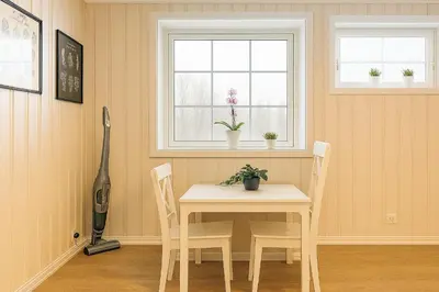 a dining room with a table and two windows at Leilighet sentralt i Bud in Bud