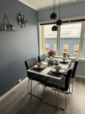 a dining room with a table and chairs and a window at Apartment by the center of Ålesund in Ålesund