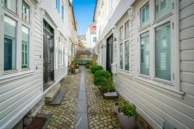 a narrow alley between two buildings with plants at Bergen style Apt I Cozy street I Easy check in in Bergen