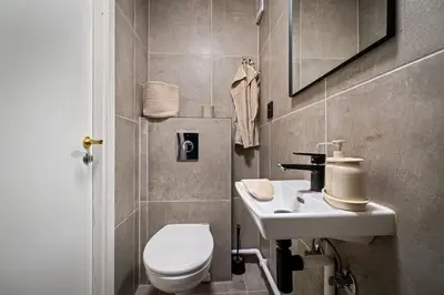 a bathroom with a white toilet and a sink at Bergen style Apt I Cozy street I Easy check in in Bergen
