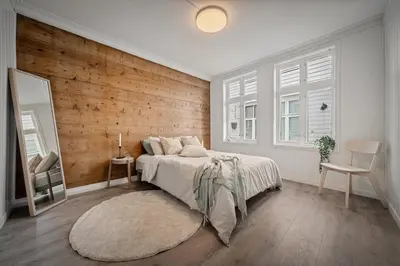 a bedroom with a bed and a wooden wall at Bergen style Apt I Cozy street I Easy check in in Bergen