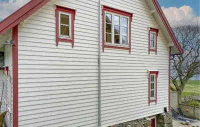 a white house with red windows on it at Stunning Home In Runde With Wifi in Runde
