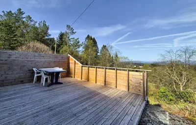 a wooden deck with a table and a fence at Awesome Home In Sletta With Wifi in Sletta