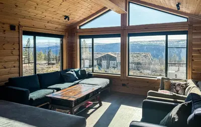 a living room with couches and a table and windows at Stunning Home In Engerdal With Wifi in Nymoen