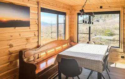 a dining room with a table and a large window at Stunning Home In Engerdal With Wifi in Nymoen