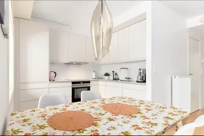 a white kitchen with a table and white cabinets at 2 bedroom, lake view, light rail, Bergen in Bergen