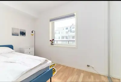a white bedroom with a bed and a window at 2 bedroom, lake view, light rail, Bergen in Bergen