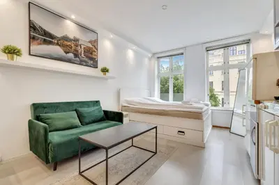 a living room with a couch and a bed at Fløyen Apartments in Bergen