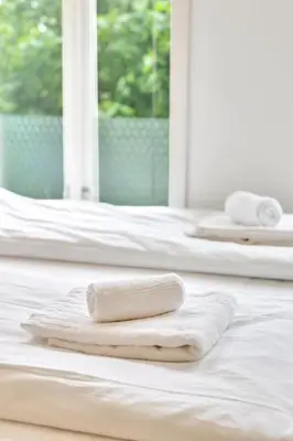 two white towels sitting on top of a bed at Fløyen Apartments in Bergen