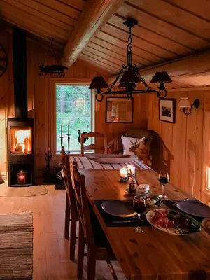 a dining room with a wooden table and a fireplace at Modern Log Cabin By Hardangervidda in Dagali