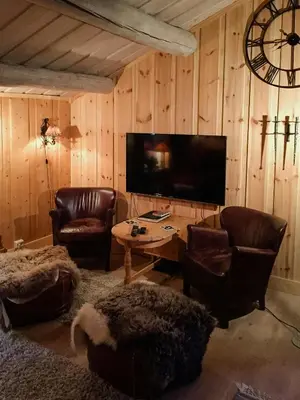 a living room with leather chairs and a flat screen tv at Modern Log Cabin By Hardangervidda in Dagali