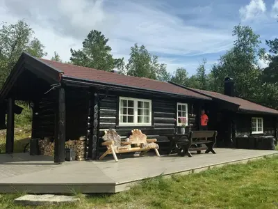 a log cabin with a bench in front of it at Modern Log Cabin By Hardangervidda in Dagali