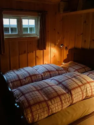 two beds sitting in a bedroom with a window at Modern Log Cabin By Hardangervidda in Dagali