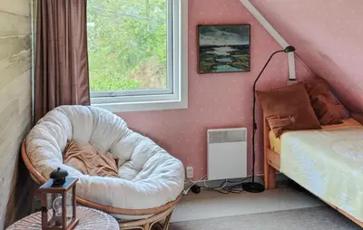 a bedroom with a bed and a chair and a window at Beautiful Home In Urangsvåg in Rolvsnes