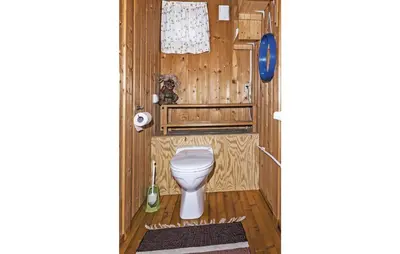 a bathroom with a toilet in a wooden room at Stunning Home In Steinstø With Wifi in Steinstø