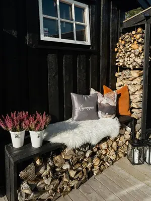 a bench with pillows sitting on a pile of wood at Idyllic Cabin By The Water In Hessdalen in Ålen