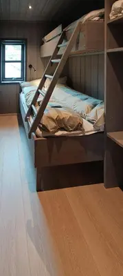 a bedroom with two bunk beds and a wooden floor at Coastal Cabin With Ocean View On Lepsøya in Kjerstad