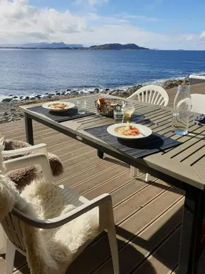 a picnic table with plates of food on the beach at Coastal Cabin With Ocean View On Lepsøya in Kjerstad