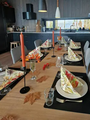 a long table with plates of food on it at Coastal Cabin With Ocean View On Lepsøya in Kjerstad