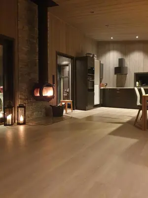a living room with a wooden floor and a kitchen at Coastal Cabin With Ocean View On Lepsøya in Kjerstad