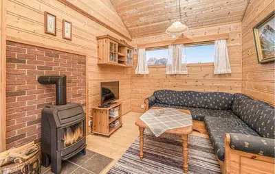 a living room with a couch and a wood stove at Awesome Home In Fjærland in Fjarland