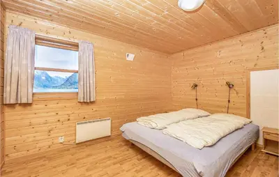 a bedroom with a bed in a wooden room at Awesome Home In Fjærland in Fjarland