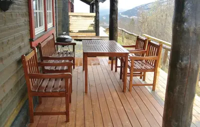a wooden deck with a table and chairs on a cabin at Amazing Home In Hemsedal With Sauna in Hemsedal